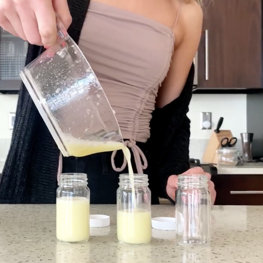 girl pouring juice shot bottles